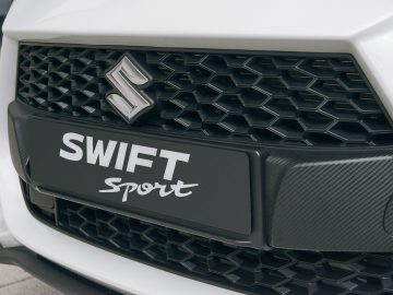 Close-up van de grille van een Suzuki Swift Sport met modelbadge.