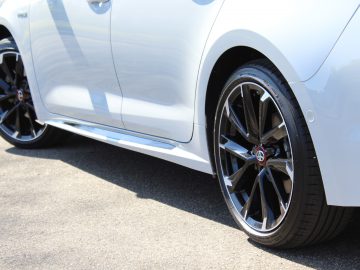 Zilveren Toyota Corolla met zwarte lichtmetalen velgen geparkeerd op asfalt.