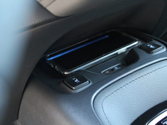 Smartphone geplaatst op het draadloze oplaadstation van een Toyota Corolla.
