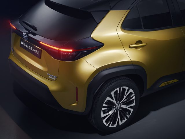 Achteraanzicht van een goudkleurige Toyota Yaris Cross, met het ontwerp en de badges van het achterlicht.