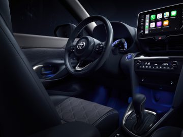 Modern Toyota Yaris Cross-interieur met verlicht dashboard, infotainmentsysteem en automatische versnellingspook.