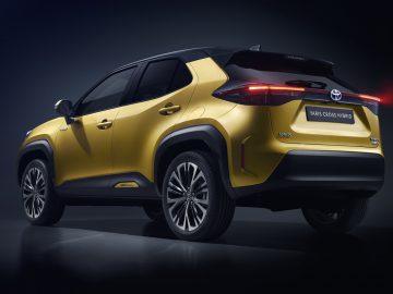 Een Toyota Yaris Cross hybride tentoongesteld met een donkere achtergrond.