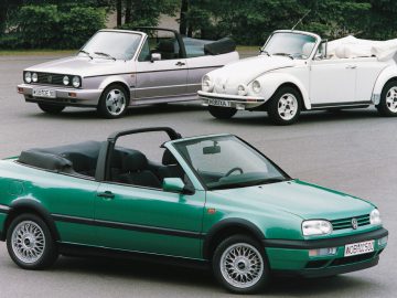 Drie Volkswagen cabrio's geparkeerd op een asfaltoppervlak.