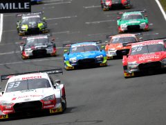 Audi DTM-toerwagens racen op een circuit tijdens een competitief autosportevenement.