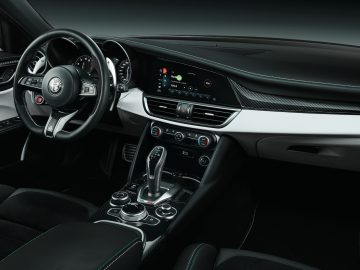 Binnenaanzicht van een moderne Alfa Romeo Giulia Quadrifoglio met het stuur, het dashboard en de middenconsole.