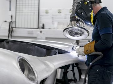 Werknemer die Aston Martin DB5 Goldfinger Vervolg lichaamsdelen las in een autofabriek.