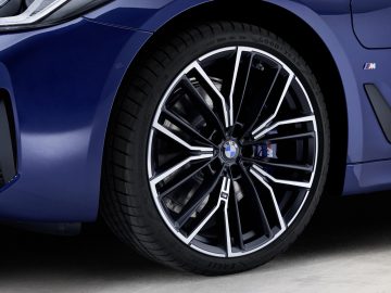 Close-up van de lichtmetalen velgen van een BMW 5 Serie-voertuig met het M-logo.
