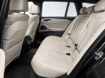 Luxe BMW 5 Serie interieur met lederen stoelen en moderne designelementen.