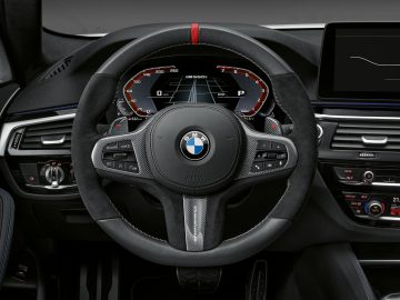 Binnenaanzicht van een BMW 5 Serie-voertuig, gericht op het stuur en het dashboard.