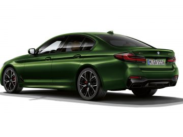 Groene BMW 5 Serie sportsedan op een witte achtergrond.