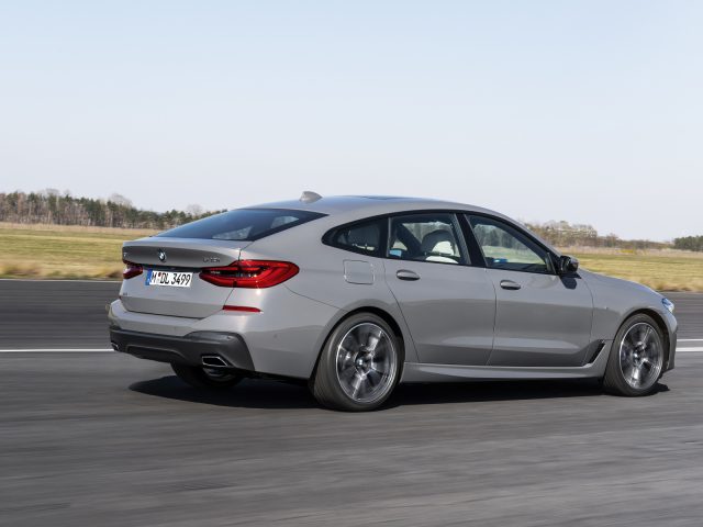 Een grijze BMW 6 Serie Gran Turismo in beweging op een racecircuit met dynamische rijcapaciteiten.