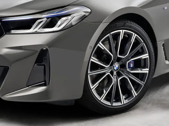 Close-up van het linkervoorwiel en de koplamp van een BMW 6 Serie Gran Turismo-auto.
