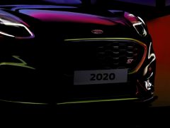 Close-up van een Ford Puma ST-model uit 2020 met prominent ST-embleem, onder dramatische verlichting.