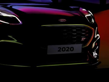 Close-up van een Ford Puma ST-model uit 2020 met prominent ST-embleem, onder dramatische verlichting.