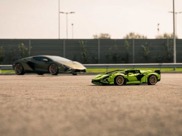 Twee Lamborghini-sportwagens op een open terrein, waarbij de dichtstbijzijnde aanzienlijk kleiner lijkt, wat erop wijst dat het een LEGO-schaalmodel of een perspectieftruc zou kunnen zijn.