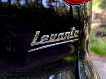 Close-up van het 'Maserati Levante Trofeo'-embleem op het zijpaneel van een zwart voertuig.
