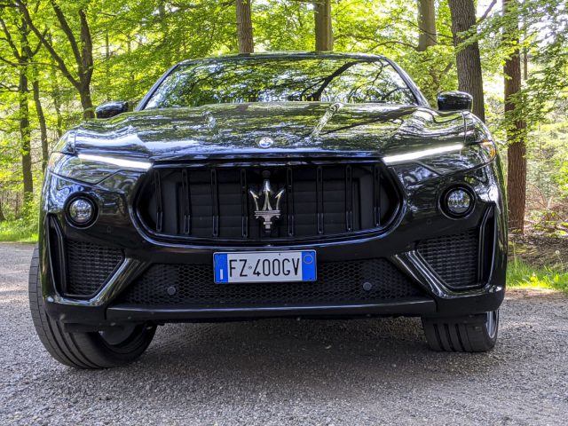Zwarte Maserati Levante Trofeo, buiten geparkeerd met een bosrijke achtergrond.
