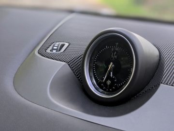 Analoge klok geïntegreerd in het dashboard van een Maserati Levante Trofeo met een bekleding van koolstofvezel.