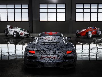 Drie krachtige auto's, waaronder een Maserati MC20, op glanzende vloer in een magazijn met grote ramen op de achtergrond.