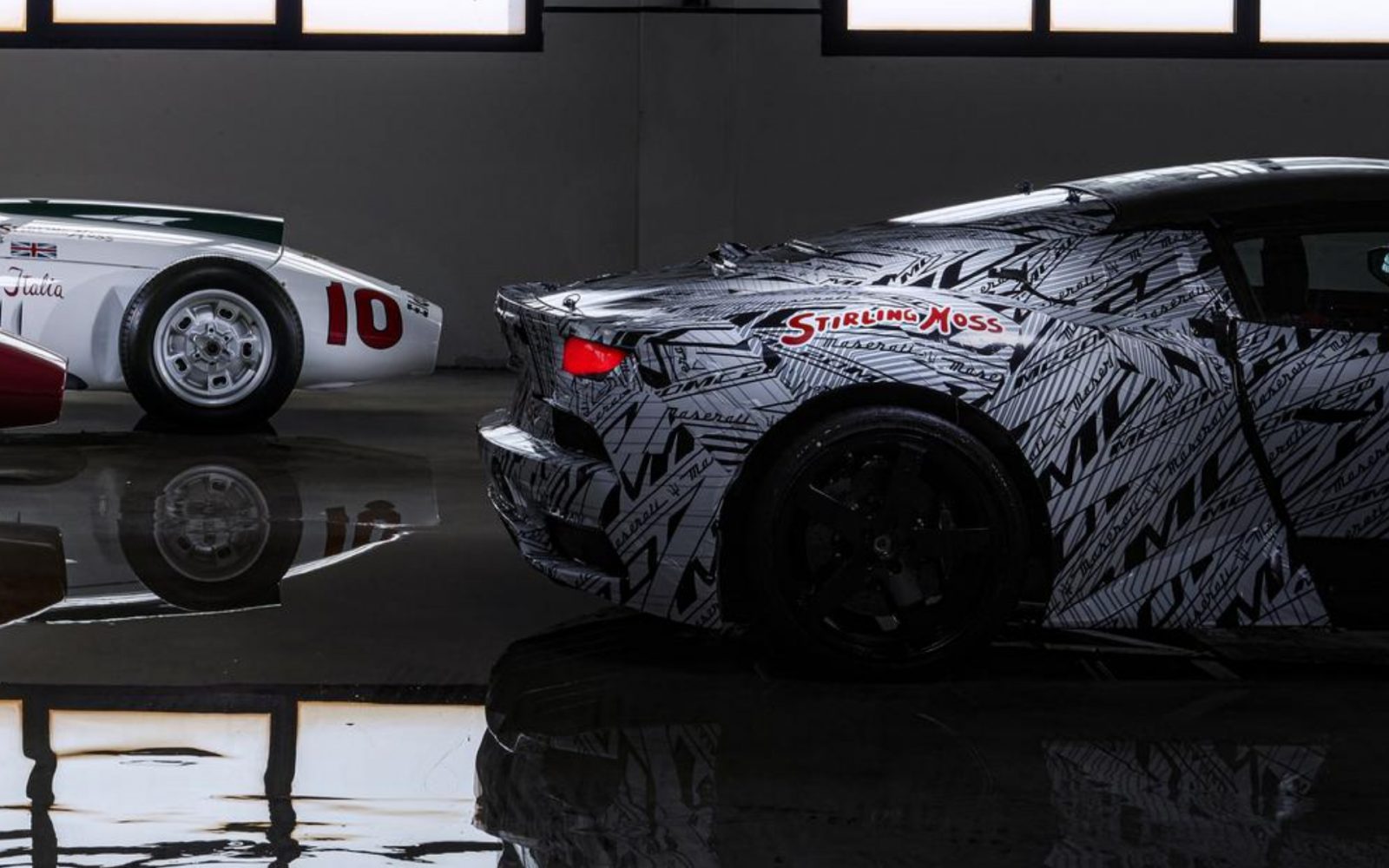 Twee Maserati MC20-sportwagens in een showroom: één met een camouflagefolie en de tekst "Stirling Moss", en een andere met een klassiek wit en rood ontwerp, nummer 10.