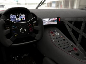 Cockpitweergave van een racesimulator met een Mazda RX-Vision GT3 Concept-stuur en digitale displays.