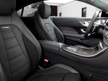 Luxe Mercedes-Benz E-Klasse interieur met lederen stoelen met rode stiksels en een modern dashboard.