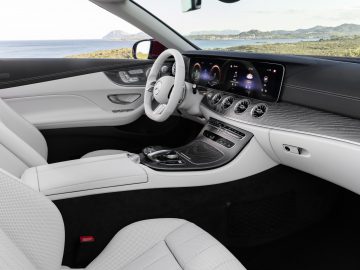 Luxe Mercedes-Benz E-Klasse-interieur met leren stoelen, een digitaal dashboard en een centrale touchscreenconsole.
