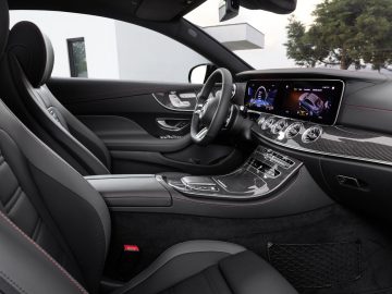 Luxe Mercedes-Benz E-Klasse interieur met modern dashboard met digitale displays, lederen stoelen en elegante middenconsole.