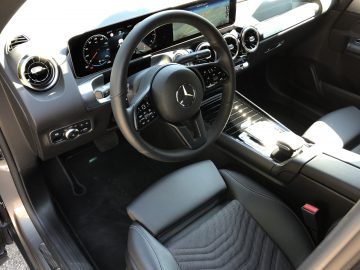 Interieur van een Mercedes-Benz GLB met lederen stuur, digitaal dashboard en middenconsole met infotainmentsysteem.