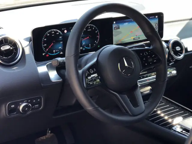 Modern Mercedes-Benz GLB-interieur met een stuur met bedieningselementen, dubbele digitale displays en middenconsole.