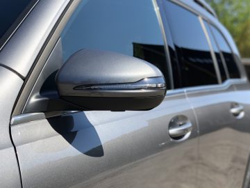 Zijaanzicht van de zilveren deur en zijspiegel van een Mercedes-Benz GLB.