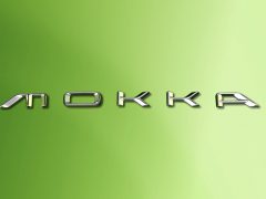 Zilveren 'Opel Mokka'-opschrift op een groene achtergrond met kleurverloop.