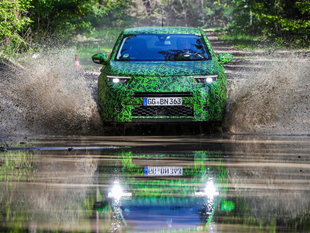 Opel Mokka spettert door water op een bospad.