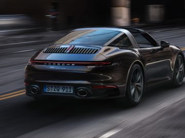 Een Porsche 911 Targa-sportwagen die snel door een stadsstraat rijdt.