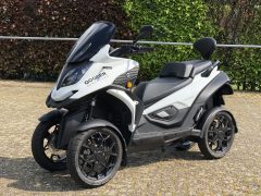 Qooder driewielige scooter buiten geparkeerd.