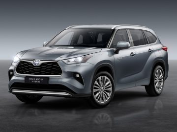 Zilveren Toyota Highlander hybride Suv op een grijze achtergrond.