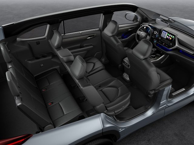 Binnenaanzicht van een Toyota Highlander met voor- en achterstoelen, dashboard en middenconsole.