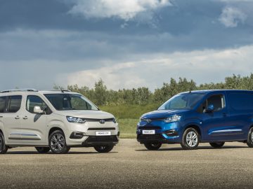 Twee Toyota ProAce City-bedrijfsvoertuigen naast elkaar geparkeerd, een passagiersvariant links en een gesloten bestelwagen rechts, buiten op een heldere dag.