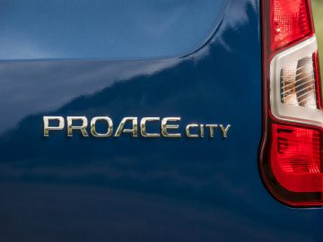 Close-up van de Toyota ProAce City-modelaanduidingsbadge op een blauw voertuig, met het achterlichtontwerp.