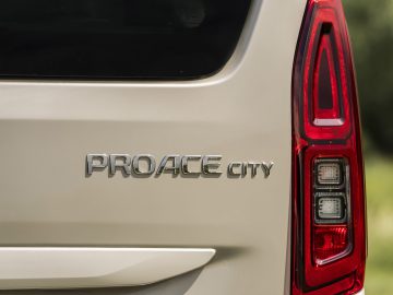 Close-up van de badge op de achterkant van een Toyota ProAce City met de tekst "proace city" naast het verticale achterlicht.