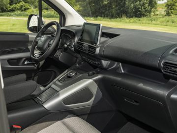 Binnenaanzicht van een Toyota ProAce City met de nadruk op het dashboard, het centrale touchscreen en het stuur.