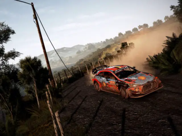 Rallyautoracen op een onverharde weg met stof achter zich aan, met WRC 9-gameplay.