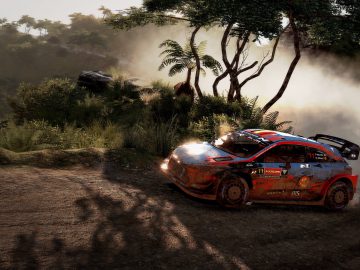 WRC 9-gameplay bevat een rallyauto die agressief over een onverharde weg navigeert met stof achter zich aan.