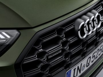 Close-up van de grille van een Audi Q5-auto met de modelnaam "quattro" en een Europees kenteken.