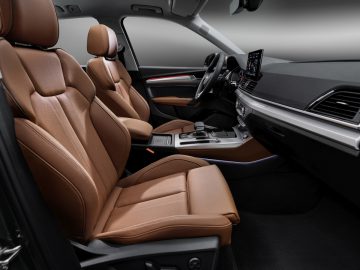 Luxe Audi Q5-interieur met modern dashboard en bruinleren stoelen.