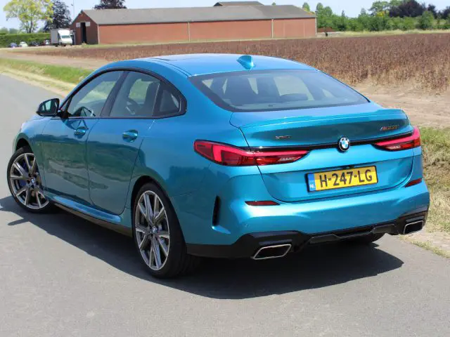 Blauwe BMW 2 Serie Gran Coupé geparkeerd aan de kant van een weg.