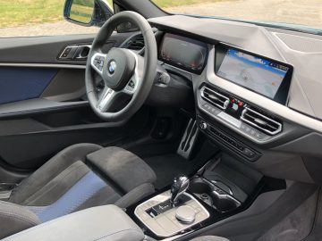 Binnenaanzicht van een BMW 2 Serie Gran Coupé met de nadruk op het stuur, het digitale dashboarddisplay en de middenconsole.