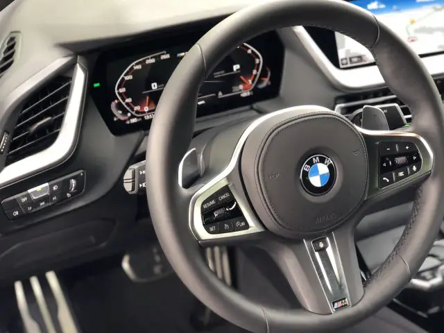 Binnenaanzicht van een BMW 2 Serie Gran Coupé-voertuig, gericht op het stuur en het dashboard.