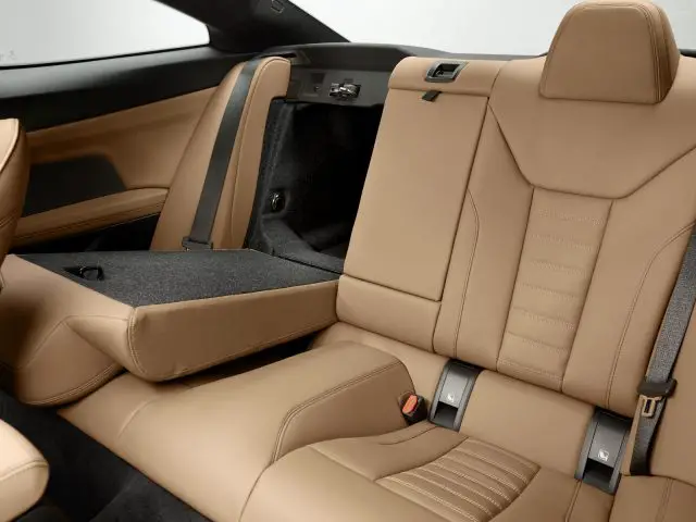 Luxe BMW 4 Serie Coupé-interieur met bruin lederen stoelen en open toegang tot de kofferbak.