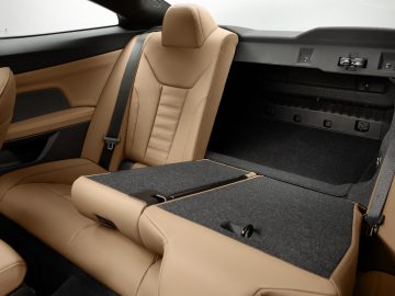 Luxe BMW 4 Serie Coupé-interieur met lederen stoelen met neerklapbare armsteun in de achtercabine.